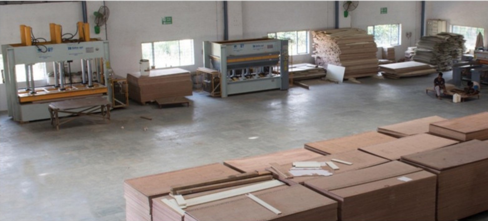The main production hall at Wada, with pressing lines along one wall and panel stock staged on the floor.