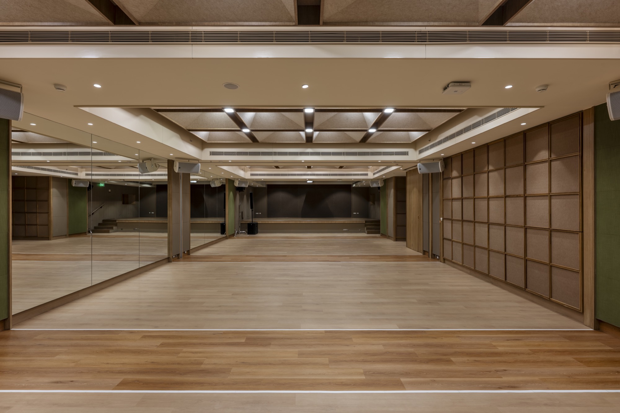 A banquet and function hall delivered by Kshitij Interiors, with a coffered ceiling and timber floor.